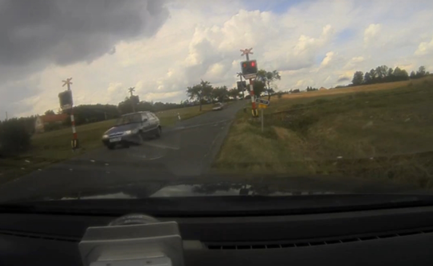 VIDEO: Nesmyslný risk! Řidič přejel železniční přejezd na červenou před očima policie
