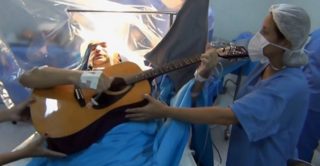 VIDEO: Pacient hrál na&nbsp;kytaru během operace mozku! Lékaři mohli sledovat škody